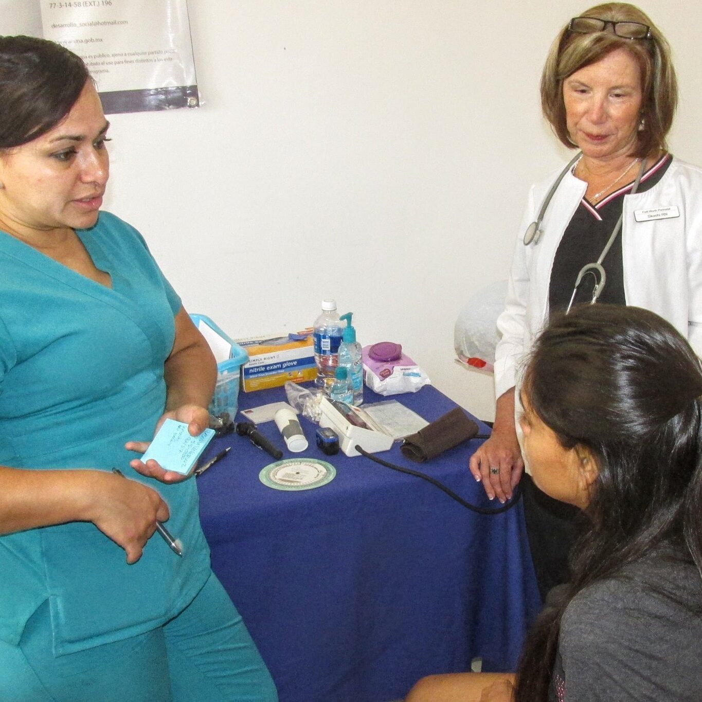 Gabby and Skoshi of AMO helping one of the young ladies from La Puerta de Esperanza.