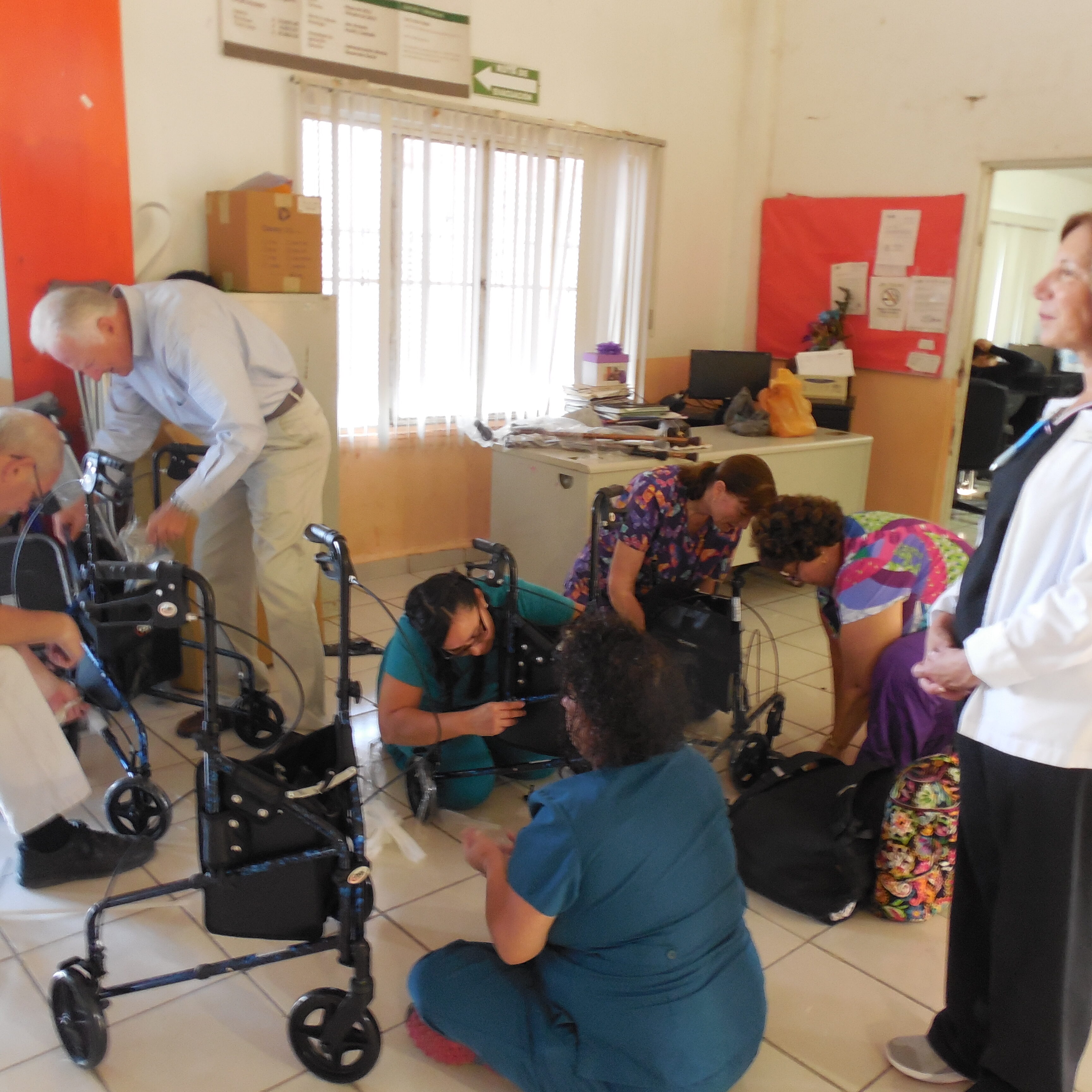 Dr. Doug  Johnson and other AMO volunteers assembling wheelchairs and walkers donated by AMO.