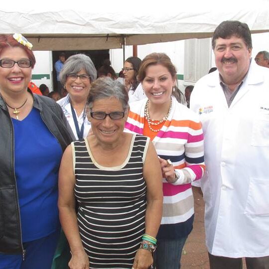 Patient receiving glasses from AMO Rosemarie with Esther and Dr. Valdez of DIF